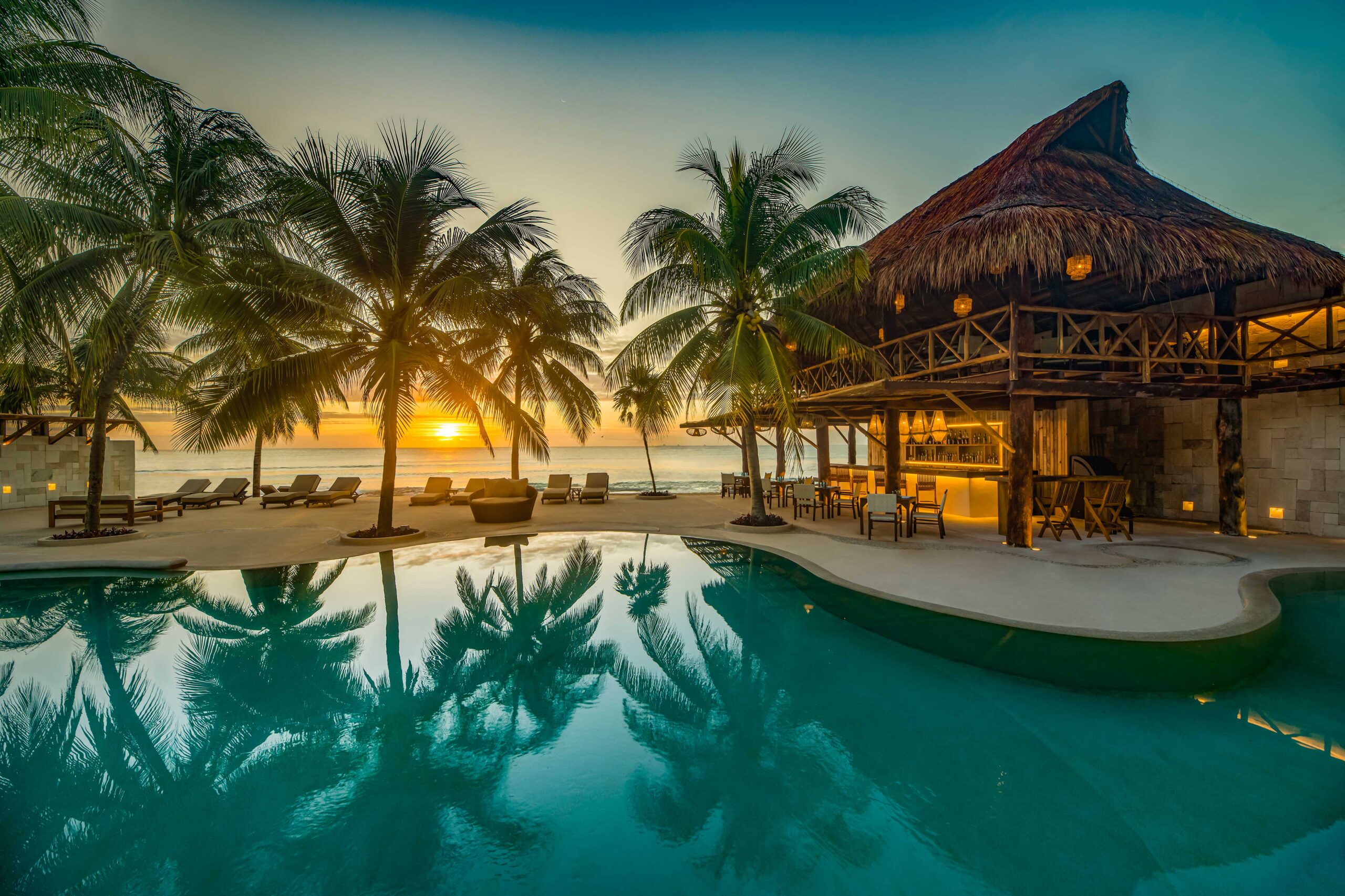 Viceroy Riviera Maya – Pool mit Palmen und Palapa-Strandrestaurant